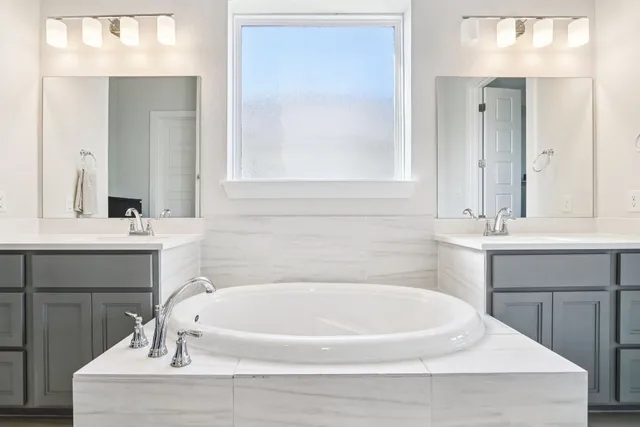 a bathroom with a tub sink and a mirror