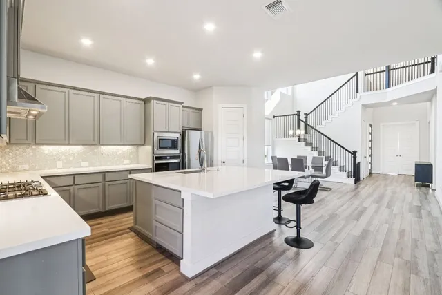 a kitchen with cabinets and wooden floor