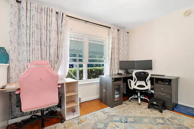 a view of a workspace with furniture and a window