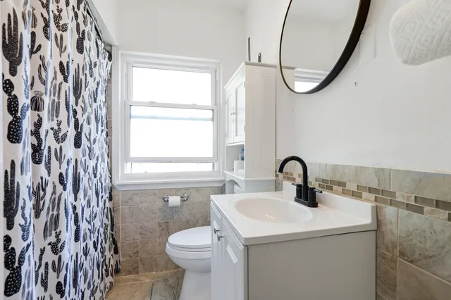 a bathroom with a sink a toilet and a mirror