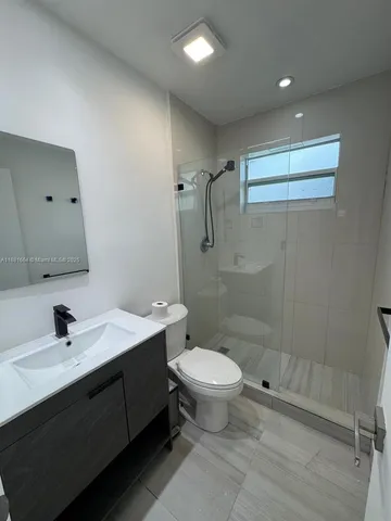 a bathroom with a sink toilet a mirror and shower