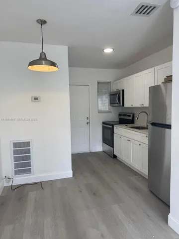 a kitchen with a refrigerator a stove top oven a sink and dishwasher