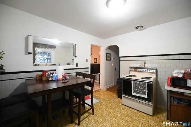 a kitchen with stainless steel appliances stove top oven table and chairs