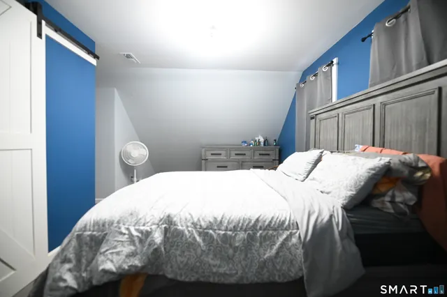 a bed sitting in a bedroom next to a wooden cabinet