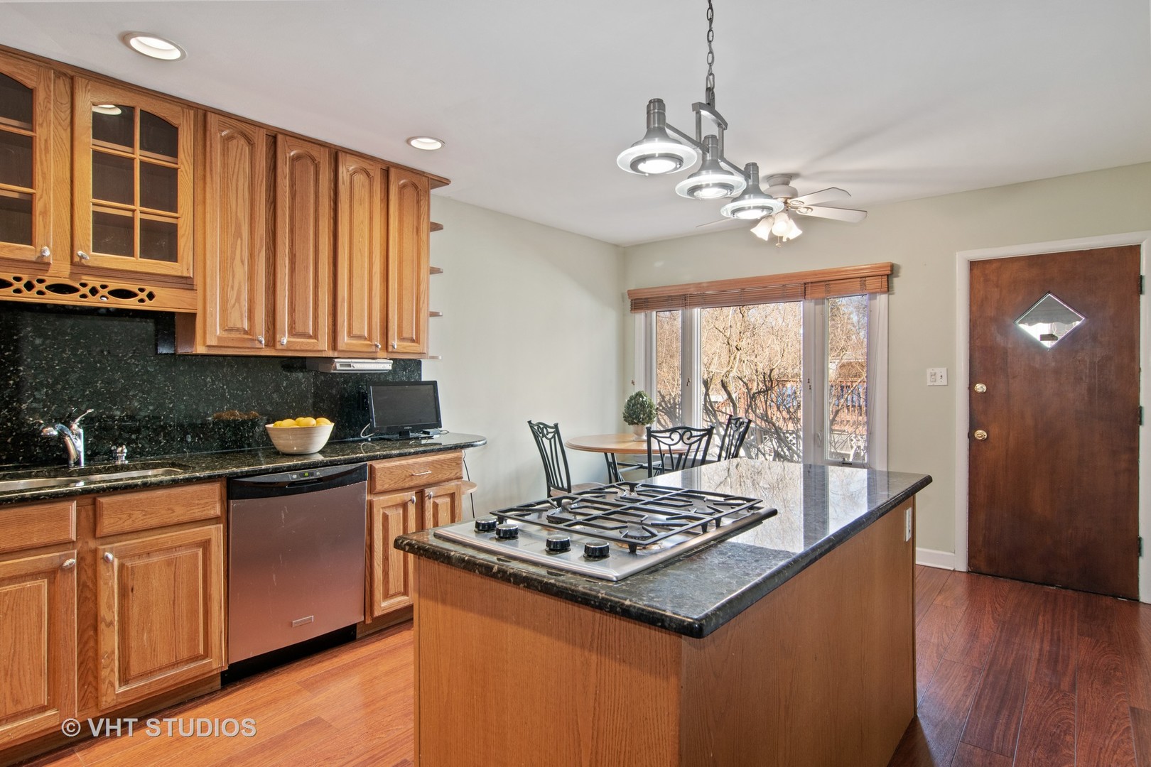 430 Longcommon Road Riverside, IL 60546 - Photo 4 of 20 a kitchen with kitchen island granite countertop a stove a sink a refrigerator wooden floor and cabinets