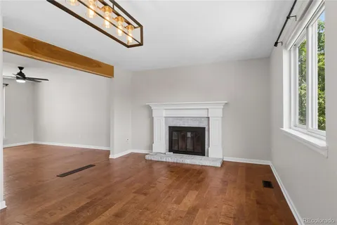 an empty room with windows and fireplace