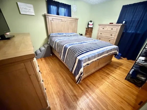 a bedroom with a bed and wooden floor