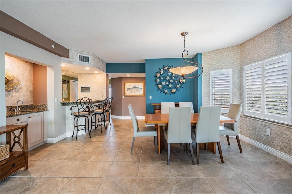 399 150th Avenue, Unit 315 Madeira Beach, FL 33708 - Photo 13 of 53 a dining room filled chandelier and fireplace