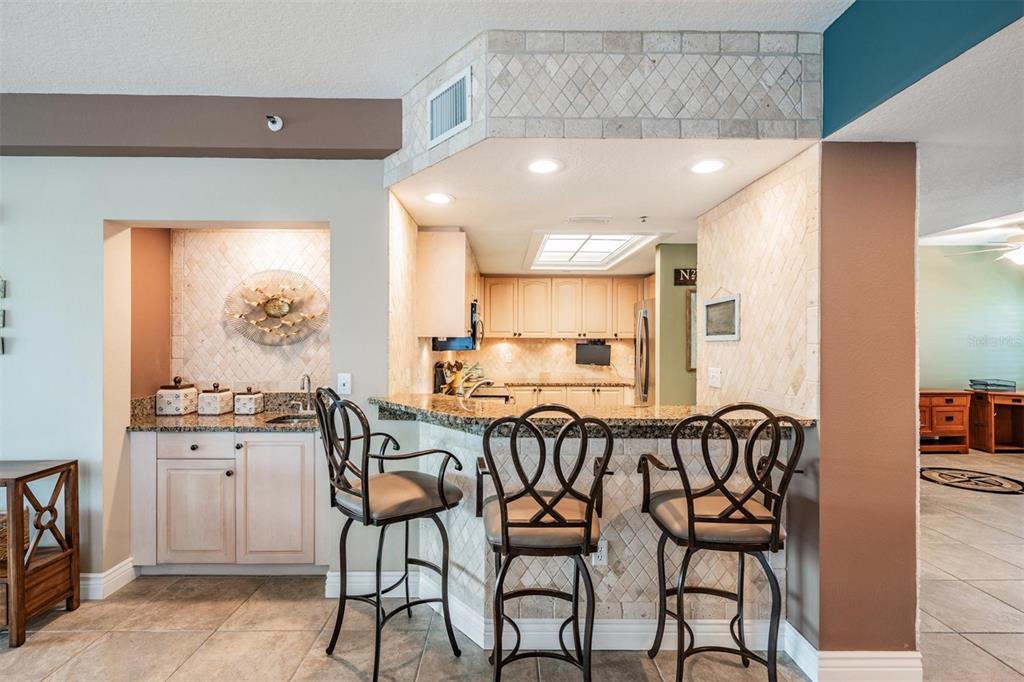 399 150th Avenue, Unit 315 Madeira Beach, FL 33708 - Photo 14 of 53 a kitchen with a table and chairs in it