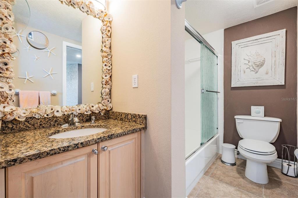 399 150th Avenue, Unit 315 Madeira Beach, FL 33708 - Photo 21 of 53 a bathroom with a granite countertop sink and a toilet