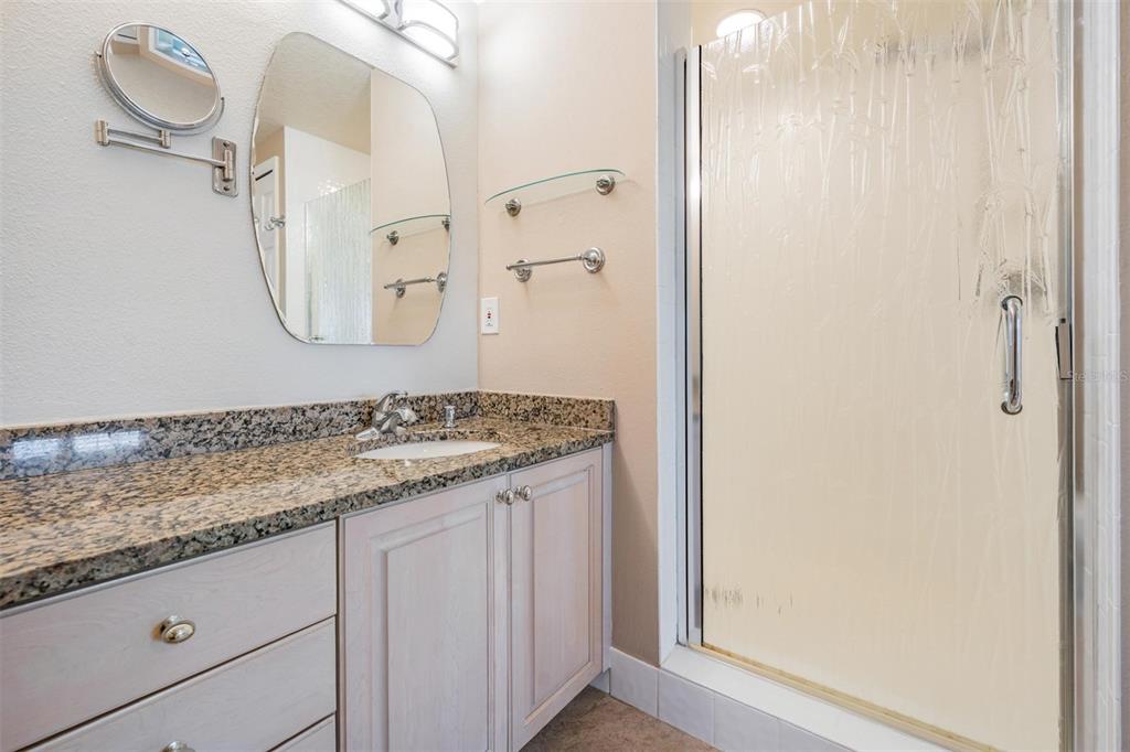 399 150th Avenue, Unit 315 Madeira Beach, FL 33708 - Photo 24 of 53 a bathroom with a granite countertop sink and a mirror