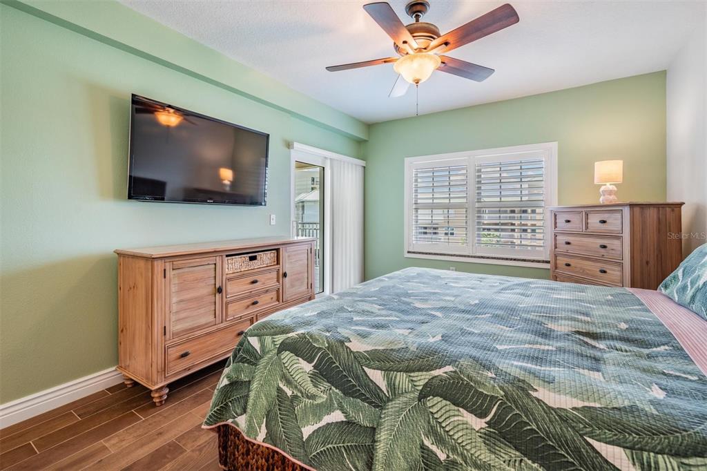 399 150th Avenue, Unit 315 Madeira Beach, FL 33708 - Photo 25 of 53 a bedroom with a bed and a flat screen tv