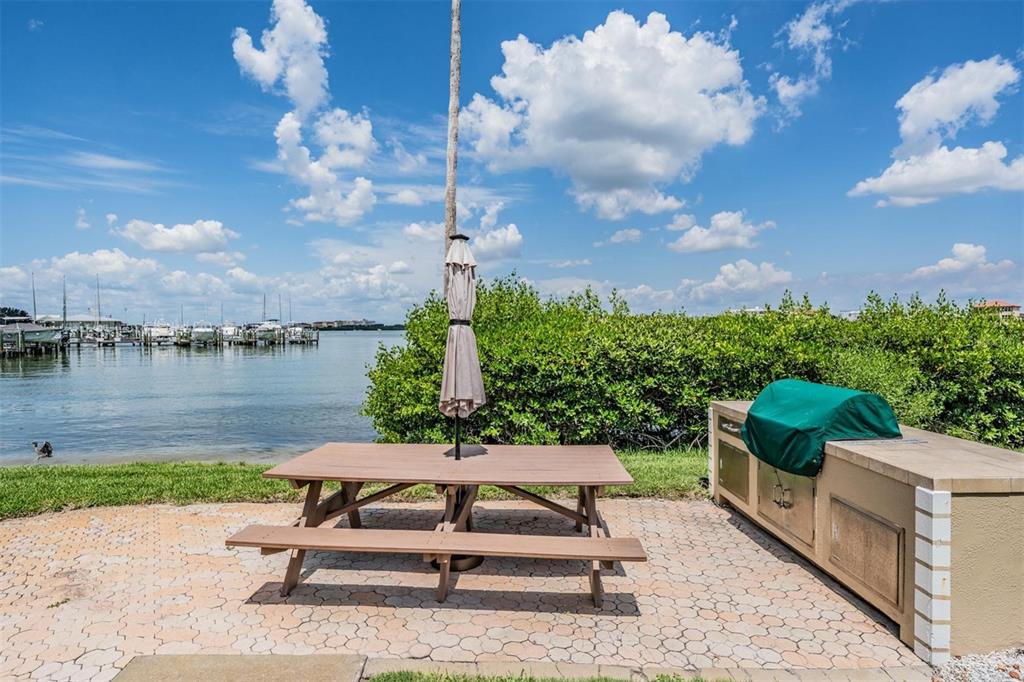 399 150th Avenue, Unit 315 Madeira Beach, FL 33708 - Photo 38 of 53 a swimming pool with outdoor seating and a lake view