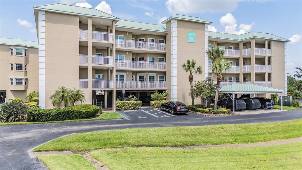 399 150th Avenue, Unit 315 Madeira Beach, FL 33708 - Photo 53 of 53 a front view of a building with a garden and plants
