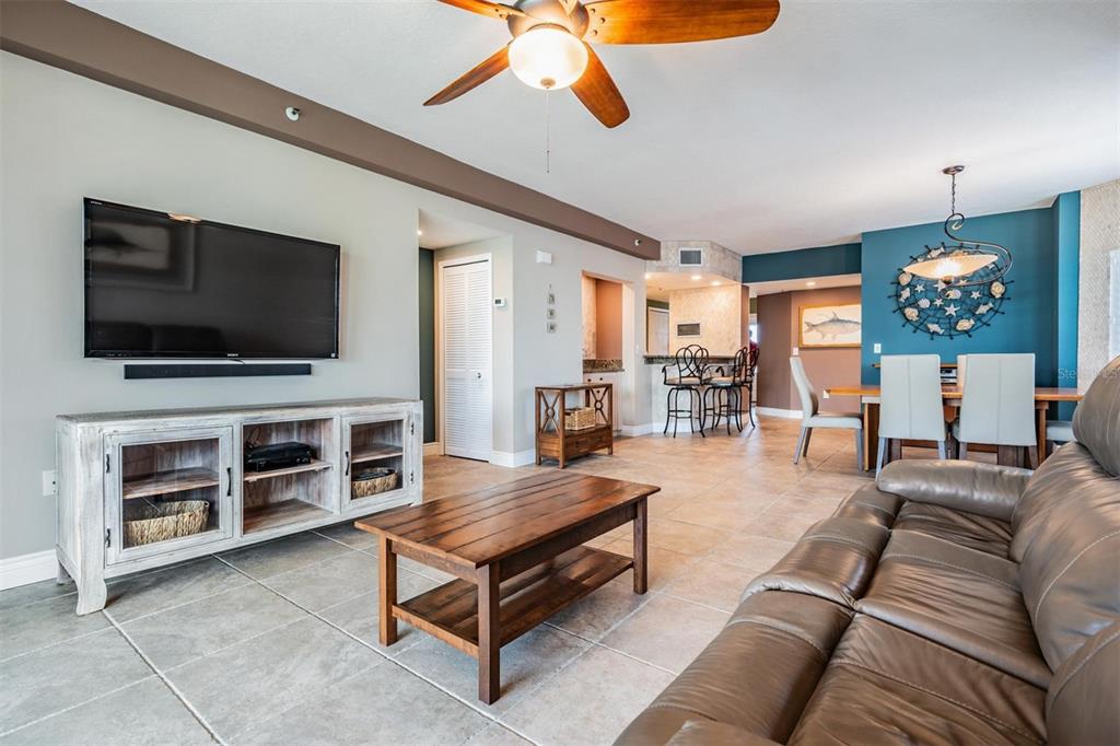 399 150th Avenue, Unit 315 Madeira Beach, FL 33708 - Photo 7 of 53 a living room with furniture and a flat screen tv