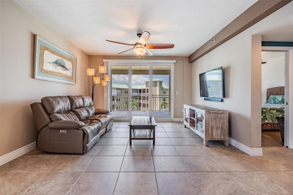 399 150th Avenue, Unit 315 Madeira Beach, FL 33708 - Photo 8 of 53 a living room with a couch and a flat screen tv