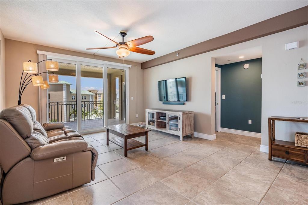 399 150th Avenue, Unit 315 Madeira Beach, FL 33708 - Photo 9 of 53 a living room with furniture a ceiling fan and a window