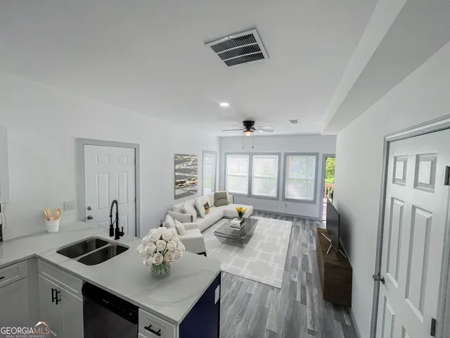 a kitchen with stainless steel appliances a refrigerator a stove a sink and white cabinets