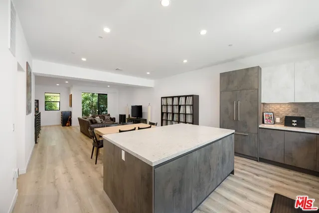 a large kitchen with kitchen island a stove a sink a refrigerator and cabinets