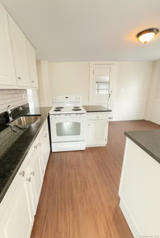 a large kitchen with wooden floors and stainless steel appliances