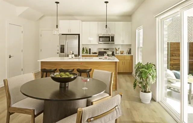 a kitchen with a dining table chairs stainless steel appliances and cabinets