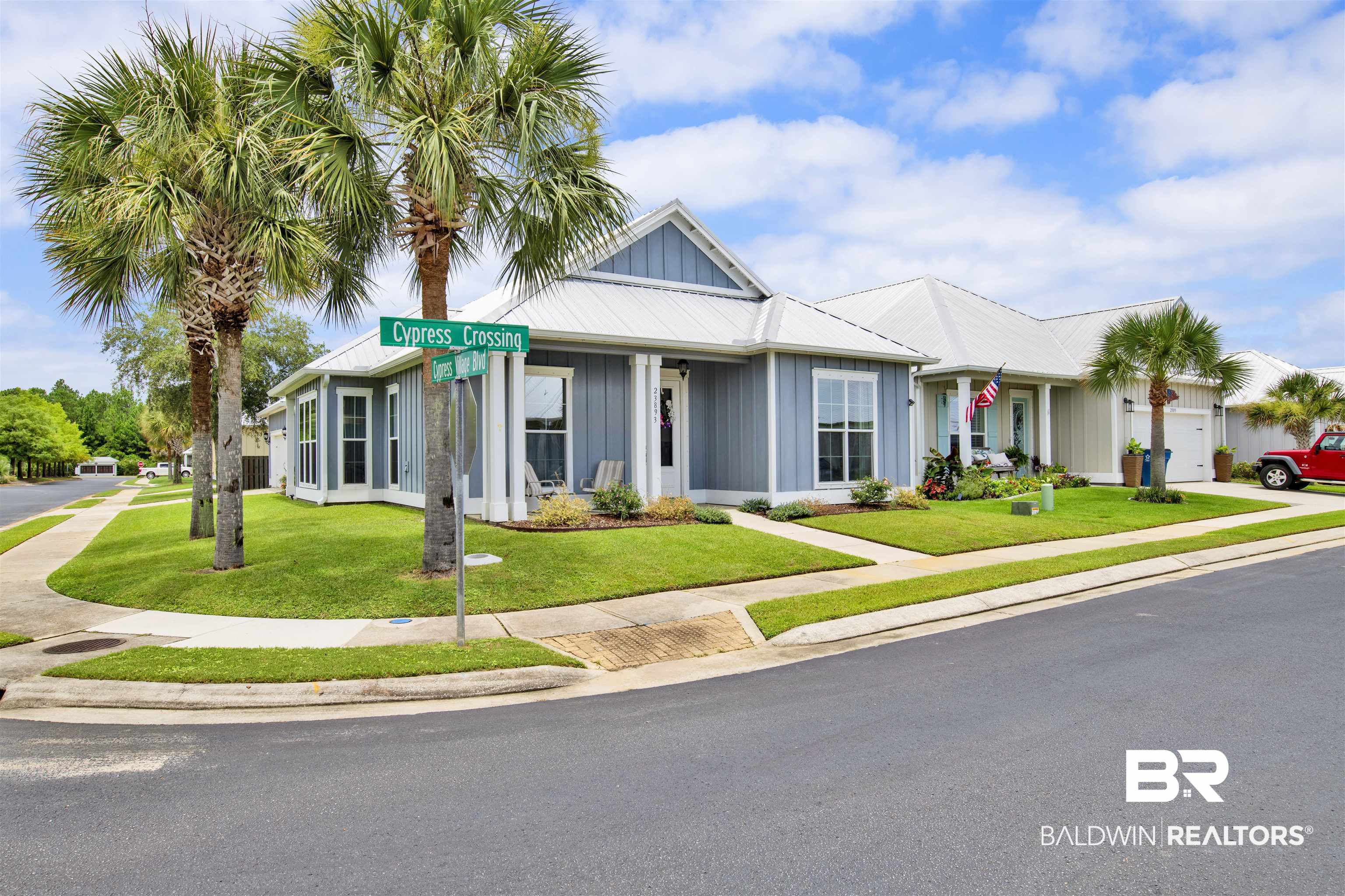 23893 Cypress Crossing Orange Beach, AL 36561 - Photo 1 of 22 View of front facade with board and batten siding, a garage, a front lawn, a metal roof, and driveway