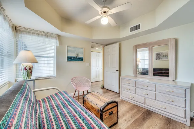 a view of a hallway with wooden floor and a bathroom