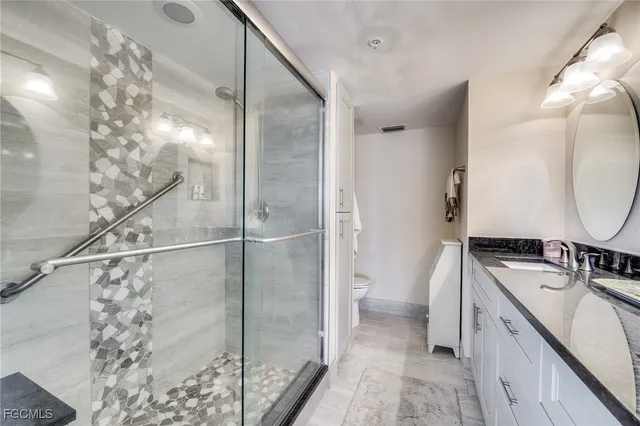 a bathroom with a granite countertop sink a mirror and a shower