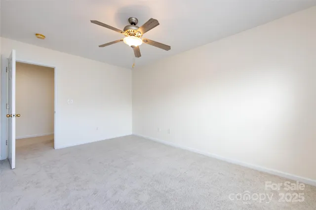 an empty room with a fan and a fan