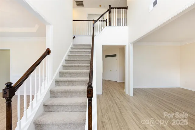 a view of staircase with wooden floor and white walls