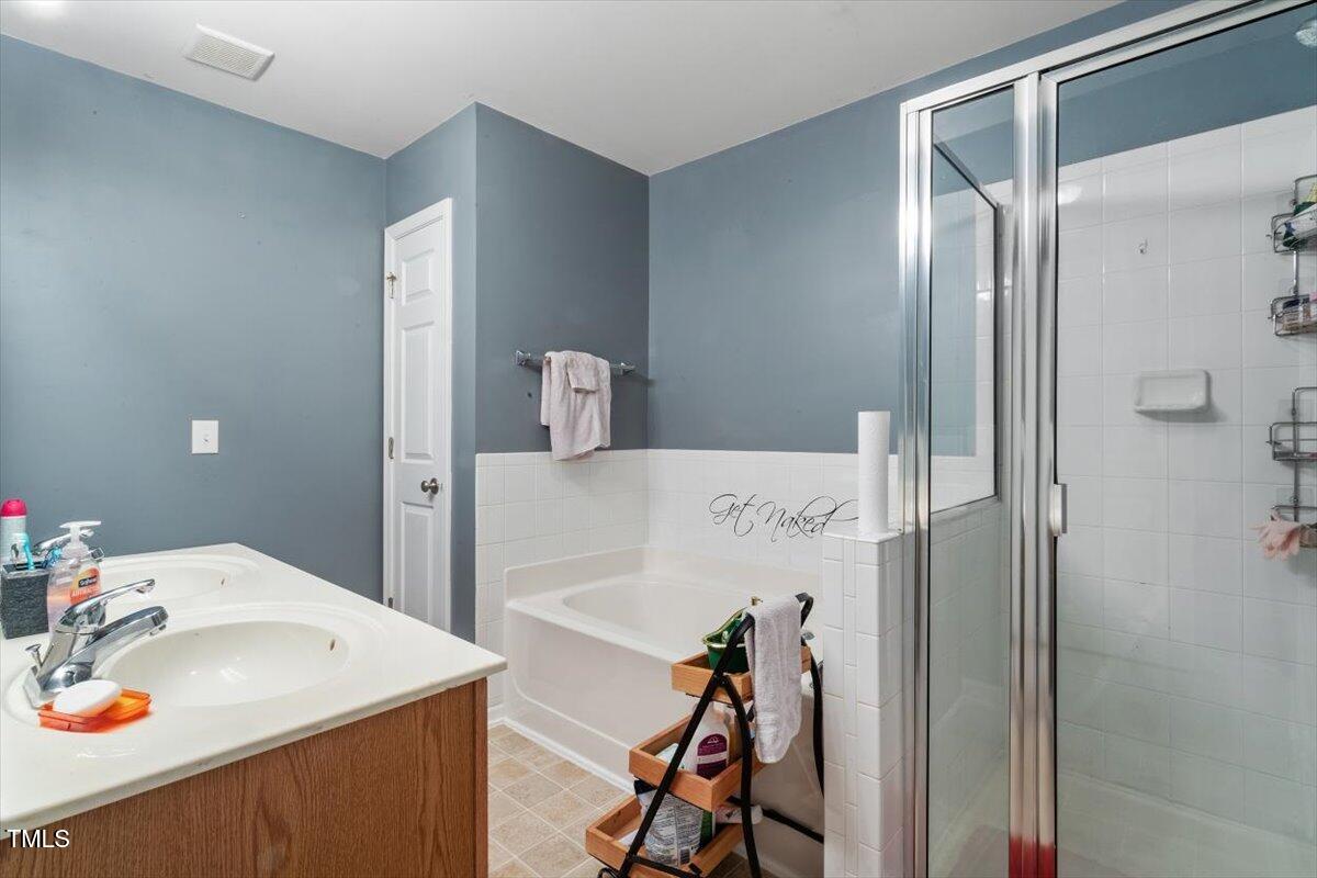 300 Gilman Lane, Unit 101 Raleigh, NC 27610 - Photo 23 of 25 a bathroom with a sink vanity and tub