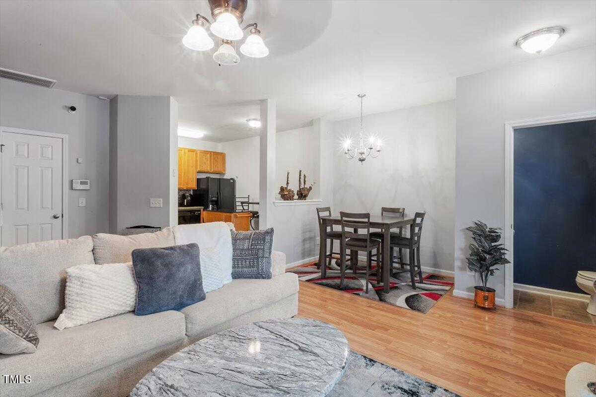 300 Gilman Lane, Unit 101 Raleigh, NC 27610 - Photo 7 of 25 a living room with furniture a dining table and a fireplace with wooden floor