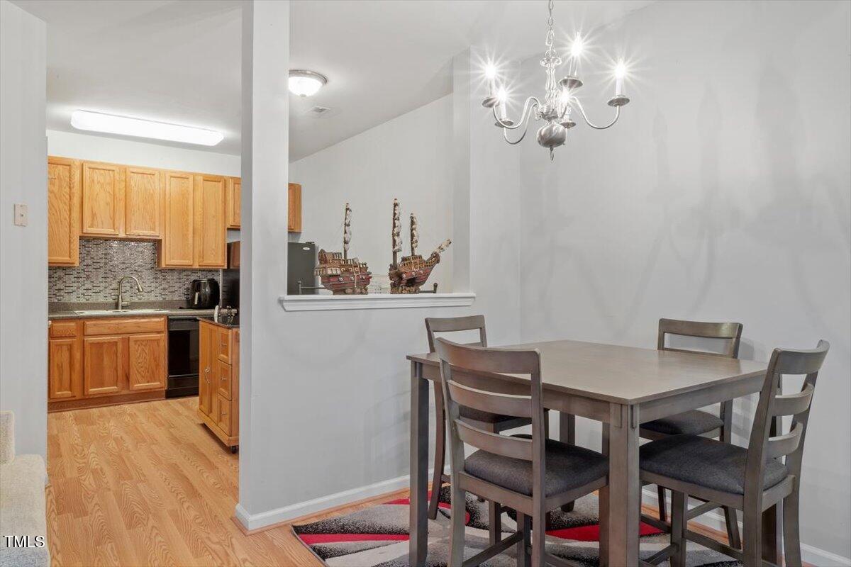 300 Gilman Lane, Unit 101 Raleigh, NC 27610 - Photo 9 of 25 a view of a dining room with furniture and chandelier