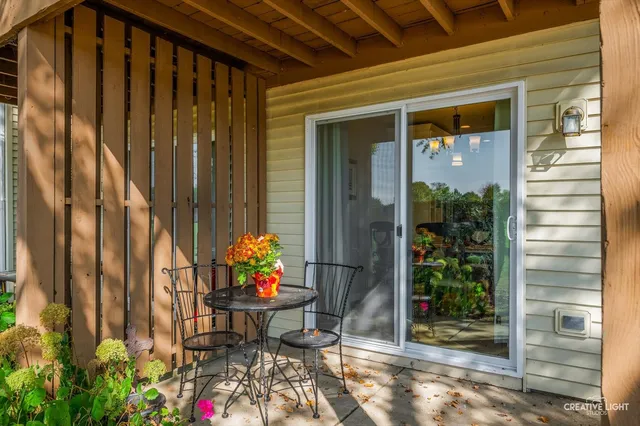 a view of a porch with a table and chairs and potted plants
