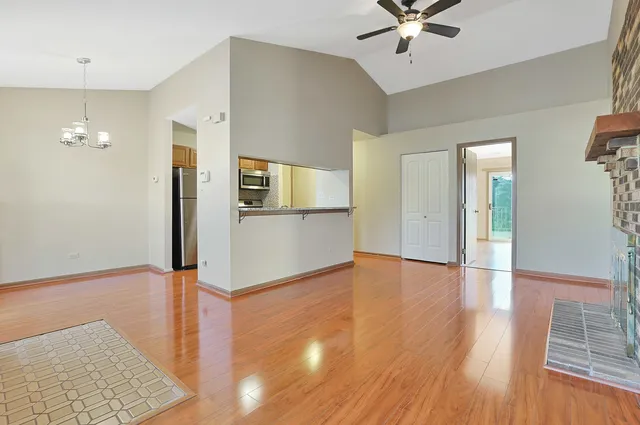 a view of a livingroom with wooden floor and a ceiling fan