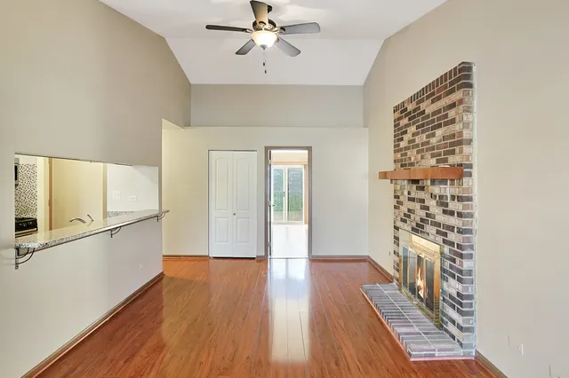 a hallway with wooden floor chandelier and entryway