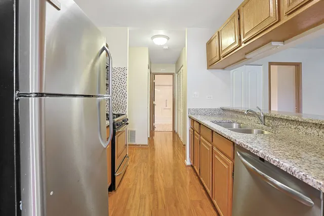 a kitchen with kitchen island a counter top space a sink and a refrigerator