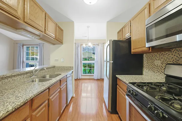 a kitchen with granite countertop a sink stove and refrigerator