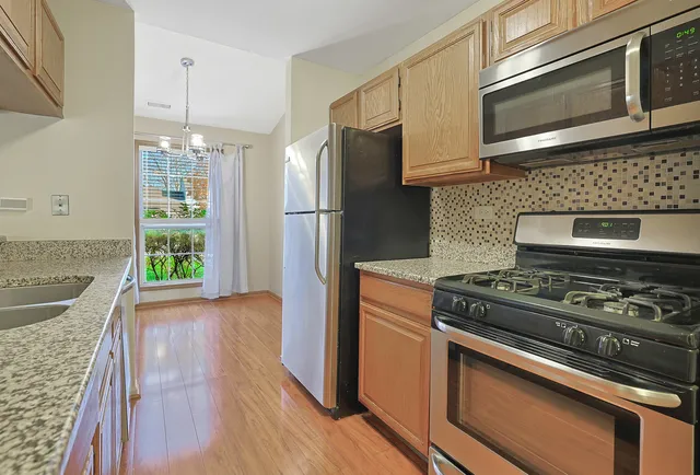 a kitchen with a stove and a wooden floor