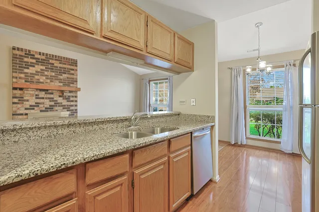 a bathroom with a granite countertop sink and a window