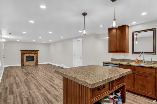 1836 West 800 North Mapleton, UT 84663 - Photo 38 of 38 Kitchen with light wood-type flooring, decorative light fixtures, open floor plan, a center island, and a glass covered fireplace