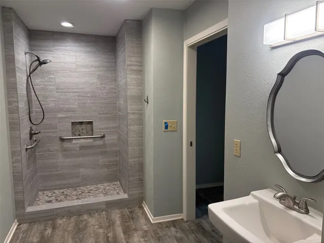 a bathroom with a sink a toilet and shower