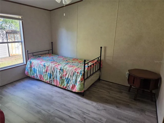 a bedroom with a bed a window and chair