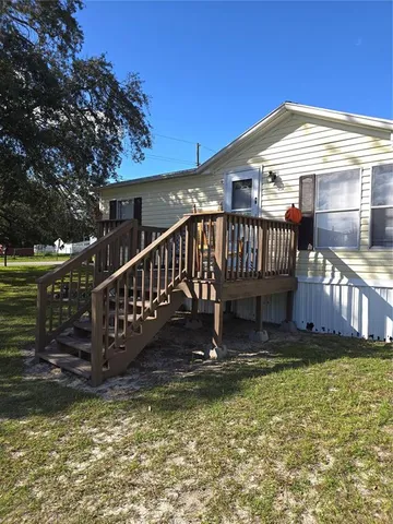 a view of a house with backyard porch and wooden fence