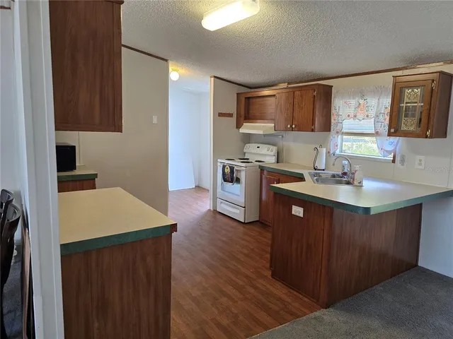 a kitchen with a sink cabinets and wooden floor