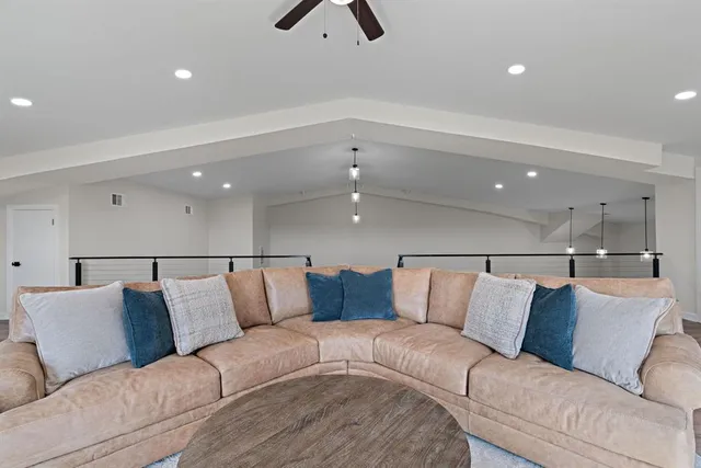 a living room with furniture and a ceiling fan
