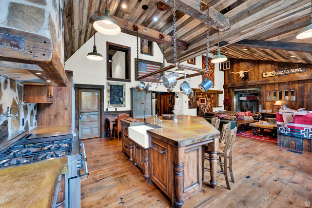 2983 East Ridgetop Road, Unit 27 Provo, UT 84604 - Photo 12 of 63 Rustic-modern kitchen anchored by a substantial wood-finish island with seating, featuring exposed beam ceiling, pendant lighting, and wood-finish flooring throughout