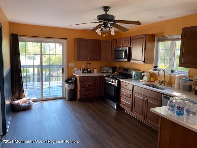 65 9th Street Belford, NJ 07718 - Photo 2 of 10 a kitchen with stainless steel appliances wooden floors stove top oven and sink