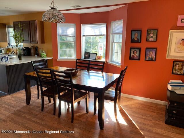 65 9th Street Belford, NJ 07718 - Photo 3 of 10 a dining room with wooden floor a chandelier a wooden table and chairs