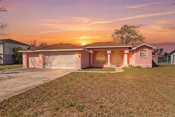 a front view of a house with a garden and yard